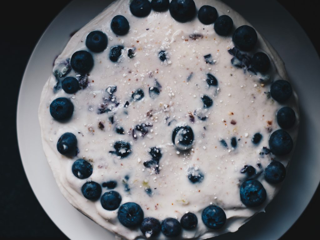 vegan lemon and blueberry cake with coconut frosting top shot