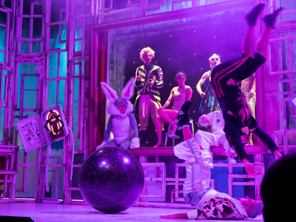 all the actors on stage are dancing and having a raucous party on the moon